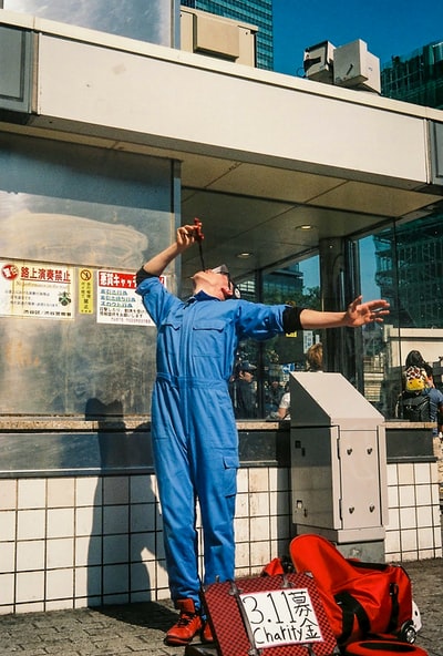 站在玻璃墙旁边的一个穿蓝色擦洗服的男人
